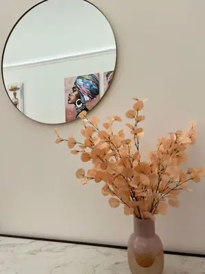 a vase with flowers in front of a mirror at Cortile Marconi Apartment in Palermo