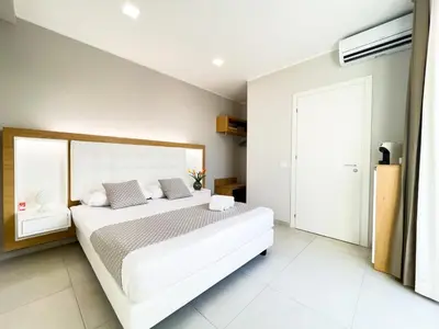 a bedroom with a large white bed and a window at Alba e Tramonto in San Vito lo Capo