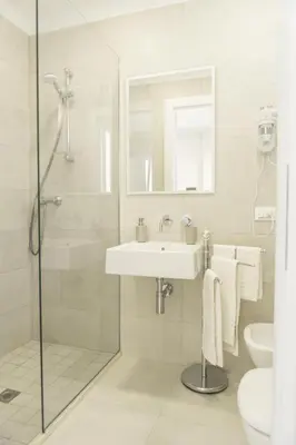 a white bathroom with a sink and a shower at Alba e Tramonto in San Vito lo Capo