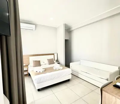 a hotel room with two beds and a television at Alba e Tramonto in San Vito lo Capo