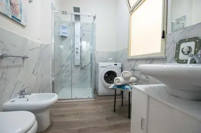 a bathroom with a sink and a washing machine at Le case di Sofia in Isola delle Femmine