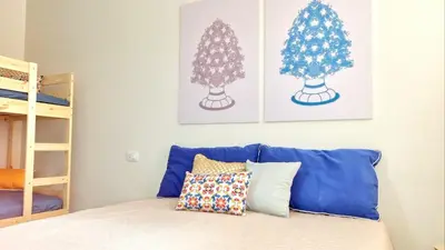 a bedroom with a blue couch and two christmas trees at Le case di Sofia in Isola delle Femmine