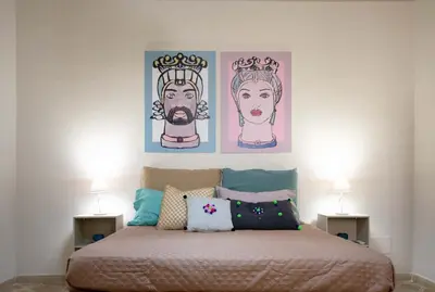 a bedroom with two pictures on the wall above a bed at Le case di Sofia in Isola delle Femmine