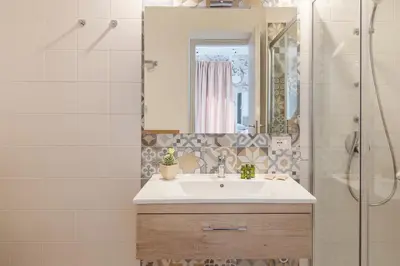 a bathroom with a sink and a shower with a mirror at LA DAMA in San Vito lo Capo