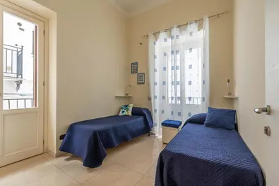 a room with two beds and a window at Olivella Apartment al Teatro Massimo by Wonderful Italy in Palermo