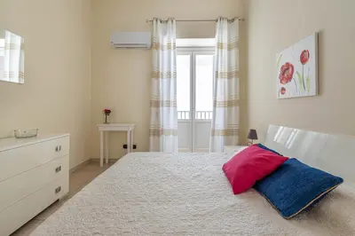a bedroom with a bed with a red and blue pillow at Olivella Apartment al Teatro Massimo by Wonderful Italy in Palermo