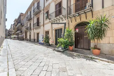 an empty street with potted plants on the side of a building at Olivella Apartment al Teatro Massimo by Wonderful Italy in Palermo