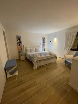 a large bedroom with a bed and a chair at Surfinia’s home in Palermo