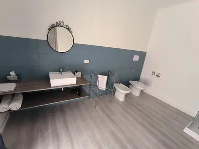 a bathroom with two toilets and a sink and a mirror at B&B Puvogel in Porticello