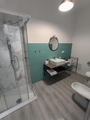 a bathroom with a sink and a shower and a toilet at B&B Puvogel in Porticello