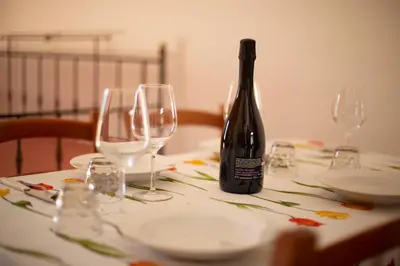 a bottle of wine sitting on a table with glasses at Hotel Iride by Marino Tourist in San Vito lo Capo
