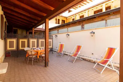 a patio with a table and chairs on it at Hotel Iride by Marino Tourist in San Vito lo Capo