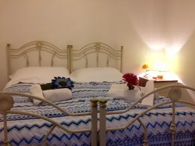 a bed with pillows and flowers on top of it at Casa Longo in Castellammare del Golfo