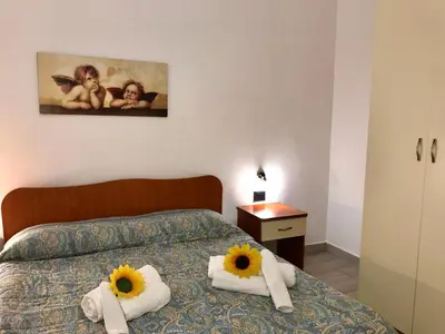 a bedroom with a bed with towels and sunflowers on it at Casa Longo in Castellammare del Golfo