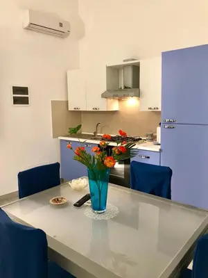 a kitchen with a table with a vase of flowers on it at Casa Longo in Castellammare del Golfo