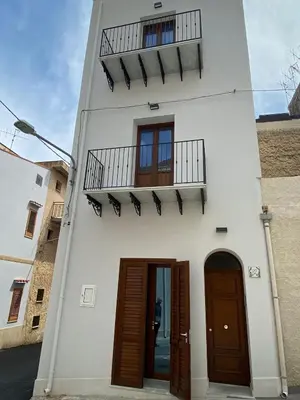 a white building with two doors and a balcony at GIADA in Castellammare del Golfo