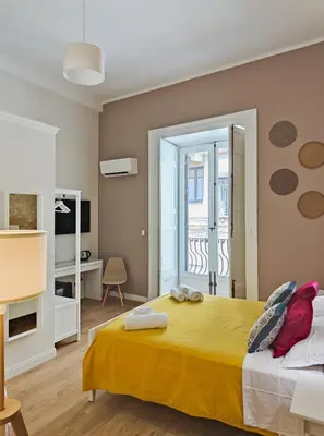 a bedroom with a large yellow bed and a balcony at Dimora Carella Ai 5Venti in Palermo