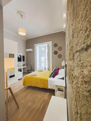 a bedroom with a yellow bed in a room at Dimora Carella Ai 5Venti in Palermo