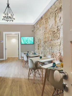 a dining room with tables and chairs and a brick wall at Dimora Carella Ai 5Venti in Palermo