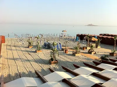 a beach with a bunch of chairs and the ocean at Hotel Sirenetta in Isola delle Femmine