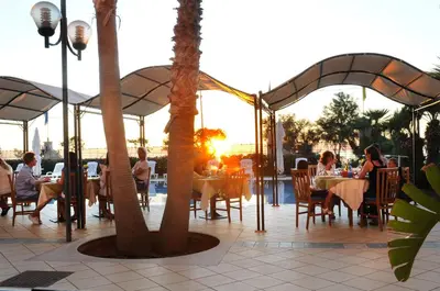 a group of people sitting at tables in a restaurant at Hotel Sirenetta in Isola delle Femmine