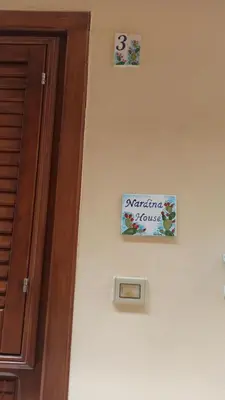 a sign on a wall next to a door at NARDINA HOUSE in Castellammare del Golfo
