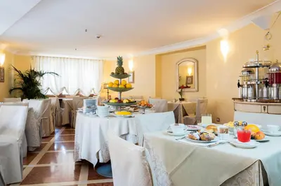 a restaurant with white tables and chairs with food on them at Hotel Vecchio Borgo in Palermo