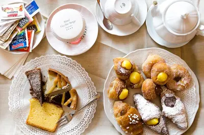 a table with plates of food and cups of coffee at Hotel Vecchio Borgo in Palermo