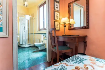 a bedroom with a desk and a sink and a toilet at Hotel Vecchio Borgo in Palermo