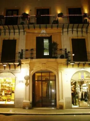 a building with a balcony on top of it at night at Albergo Verdi in Palermo