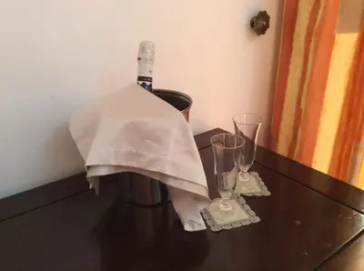 a bottle of wine and two glasses on a table at Albergo Verdi in Palermo