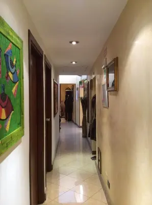 a corridor of a hallway with paintings on the walls at Albergo Verdi in Palermo