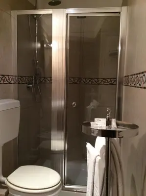 a bathroom with a shower with a toilet and a sink at Albergo Verdi in Palermo