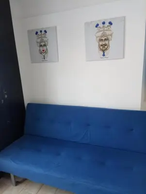 a blue bench in a room with two pictures on the wall at Mi casa es tu casa in Palermo