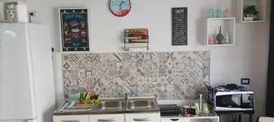 a kitchen with a sink and a tile wall at Mi casa es tu casa in Palermo