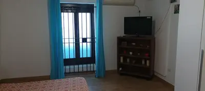 a room with a television and a door with blue curtains at Mi casa es tu casa in Palermo