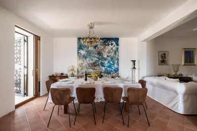 a dining room with a white table and chairs at Villa vista mare con piscina privata a Mondello in Palermo