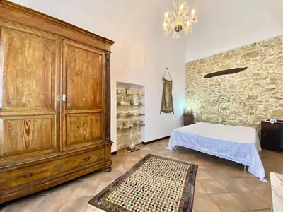 a room with a large wooden cabinet and a bed at Baglio Giganti in Alcamo