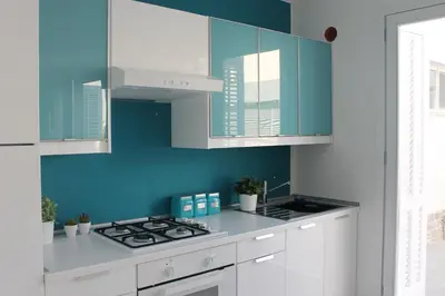 a kitchen with blue walls and a stove top oven at Mondello Suites FLH - Gorgonia in Mondello