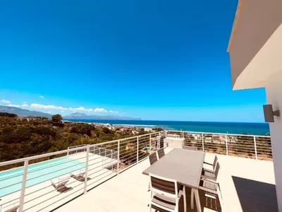 a balcony with a table and chairs and the ocean at Villa Lombardo Luxury in Balestrate