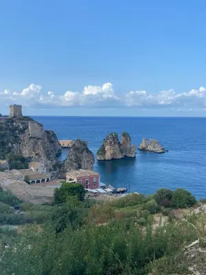 a view of the ocean with rocks and a house at La Casa di Peppe in Capaci