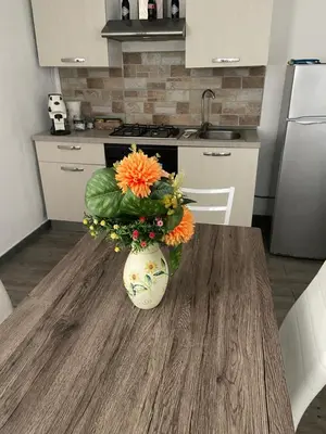 a vase with flowers on a table in a kitchen at La Casa di Peppe in Capaci