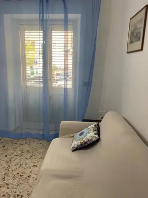 a bedroom with a bed with blue curtains and a window at Casa Repasi in Sferracavallo