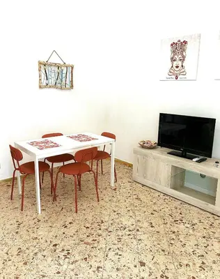a dining room with a table and chairs and a tv at Casa Repasi in Sferracavallo