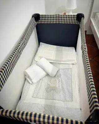 a baby crib with a teddy bear in it at Sikelia Apartment in Palermo
