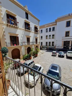 a group of cars parked in a parking lot next to a building at Sikelia Apartment in Palermo