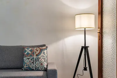 a lamp sitting next to a couch with a pillow at Sicilia Bella Maqueda in Palermo