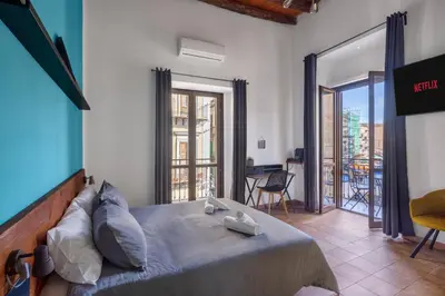 a bedroom with a large bed and a balcony at Suk Ballarò in Palermo
