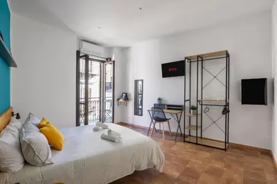 a bedroom with a large bed and a desk at Suk Ballarò in Palermo