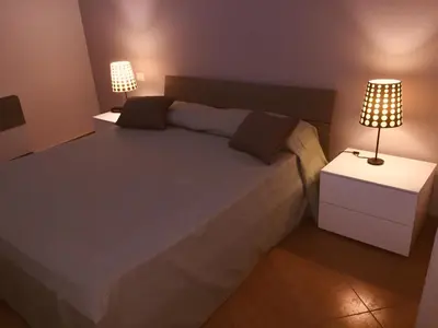 a bedroom with a large bed with two lamps at Hola Cathedral House Cadorna in Palermo